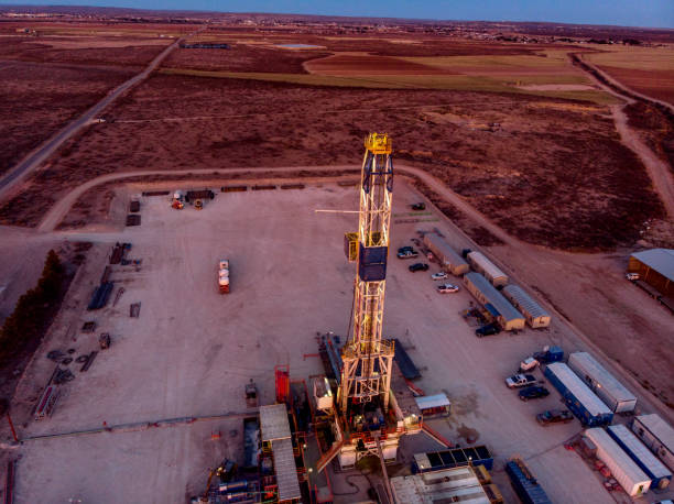 vue de drone d’un pad de plate-forme de fracturation de forage de pétrole ou de gaz pendant que le soleil se couche au nouveau-mexique - oil industry industry new mexico oil drill photos et images de collection