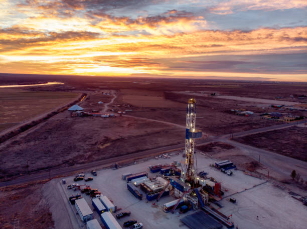 vue de drone d’un pad de plate-forme de fracturation de forage de pétrole ou de gaz pendant que le soleil se coucherait au nouveau-mexique - oil industry industry new mexico oil drill photos et images de collection