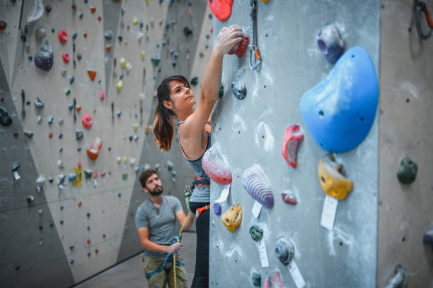 istock Belayer Watching Female Sport Climber Ascending Pillar 1301107375