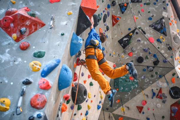 istock Strong Male Athlete Dangling Off Vertical Climbing Wall 1301107393
