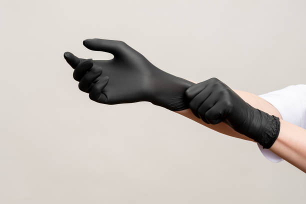 chef hands kitchen hygiene black latex gloves Chef hands. Kitchen hygiene. Woman wearing black latex gloves isolated on light copy space background. Professional culinary. Master class. surgical glove stock pictures, royalty-free photos & images