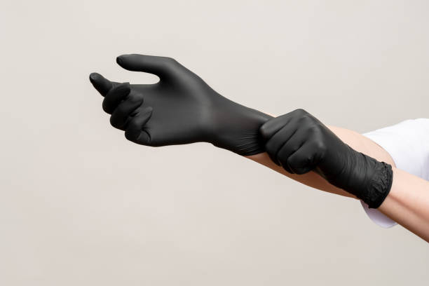 chef hands kitchen hygiene black latex gloves Chef hands. Kitchen hygiene. Woman wearing black latex gloves isolated on light copy space background. Professional culinary. Master class. protective glove stock pictures, royalty-free photos & images