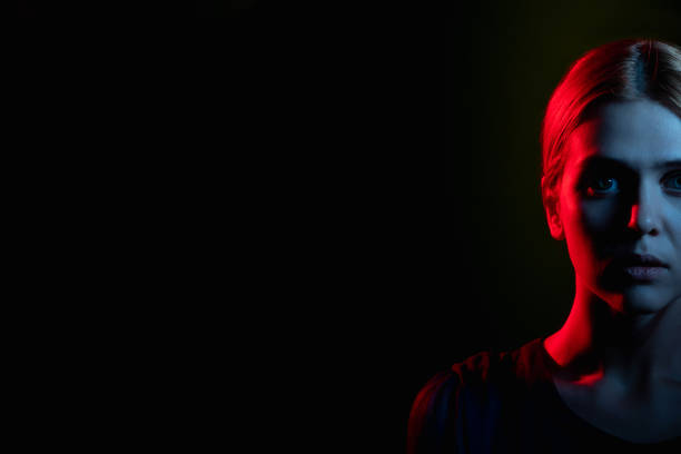 istock female silhouette portrait neon light scared woman 1301107468