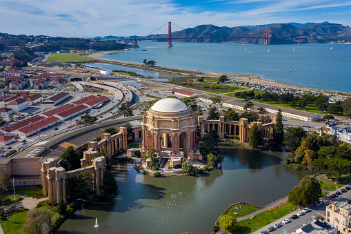 Aerial view on a sunny day of Palace of Fine Arts and Golden Gate Bridge in the background.