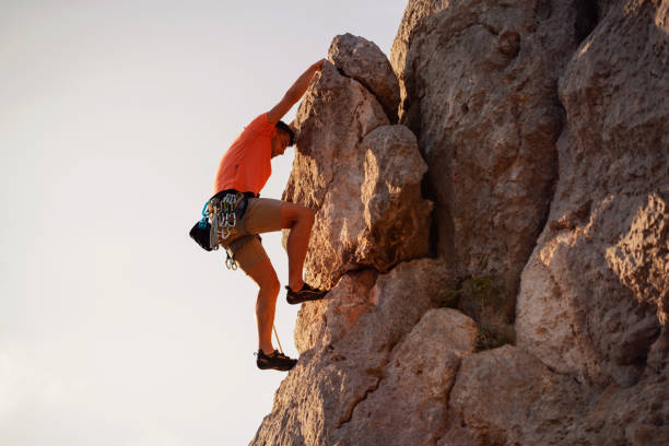 istock Low angle view of a young climber holding for a cliff 1301112004
