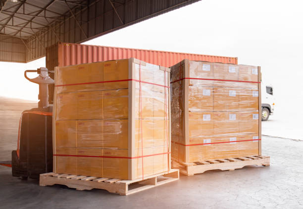 istock Cargo shipment loading for truck. Freight truck for delivery service. Warehouse dock load pallet goods into container truck. Stacked boxes wrapped plastic on pallet rack. 1301112958