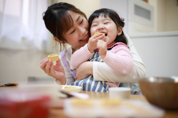 parents and children eating the sweets they made - child eating imagens e fotografias de stock