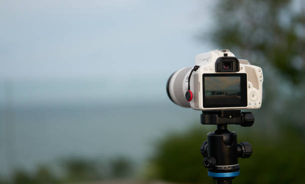 istock Tourist white camera on stand on blur beach front view 1301114098