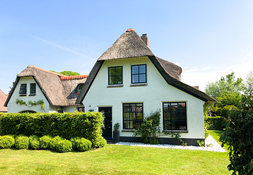 Langweer, Friesland, Netherlands: An old-fashioned house with a thatched roof in downtown Langweer in springtime.