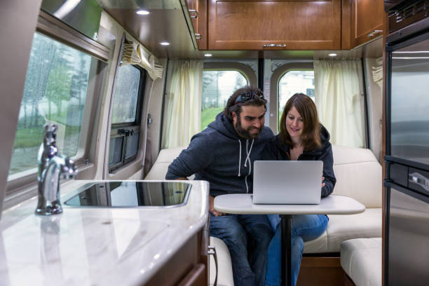 istock Young Couple Using Laptop Inside Motor Home 1301116823
