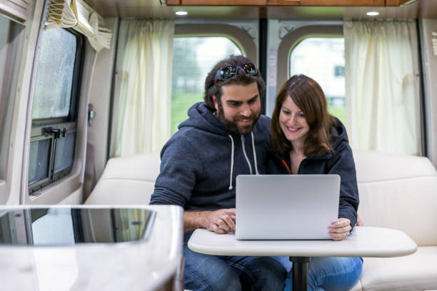 istock Young Couple Using Laptop Inside Motor Home 1301116866