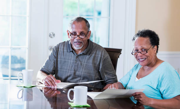 istock Senior couple at home review brochures 1301117737