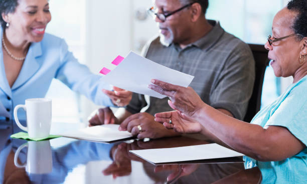 istock Senior couple at home with financial advisor 1301117779