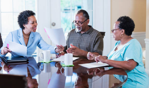istock Senior couple at home with financial advisor 1301117806