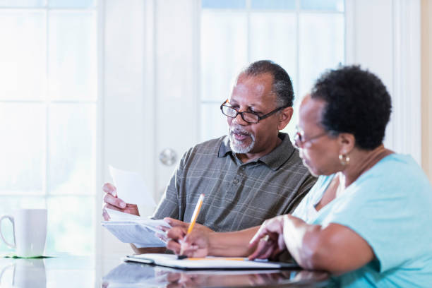 coppia anziana a casa che paga le bollette - retirement senior adult finance couple foto e immagini stock