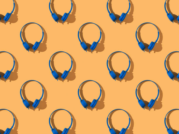 istock A pattern of bright blue headphones on an orange background. 1301118653