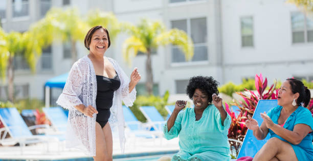 istock Three senior women vacationing, dancing on pool deck 1301118717