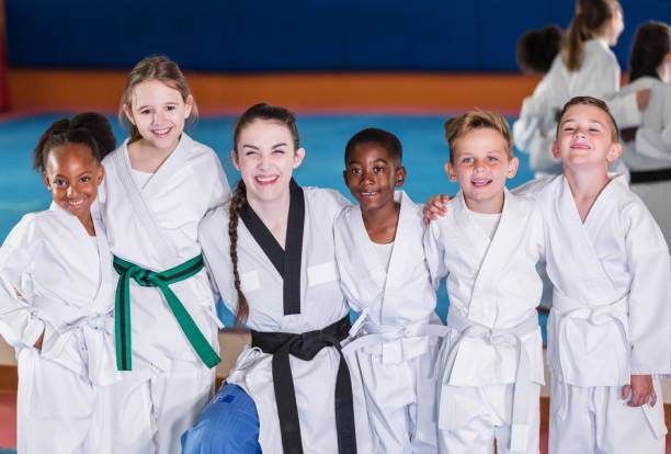 professeur, enfants dans la classe de taekwondo - arm around caucasian latin american and hispanic ethnicity child photos et images de collection