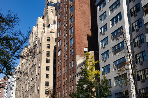 A row of beautiful brick residential skyscrapers along a street on the Upper East Side of New York City