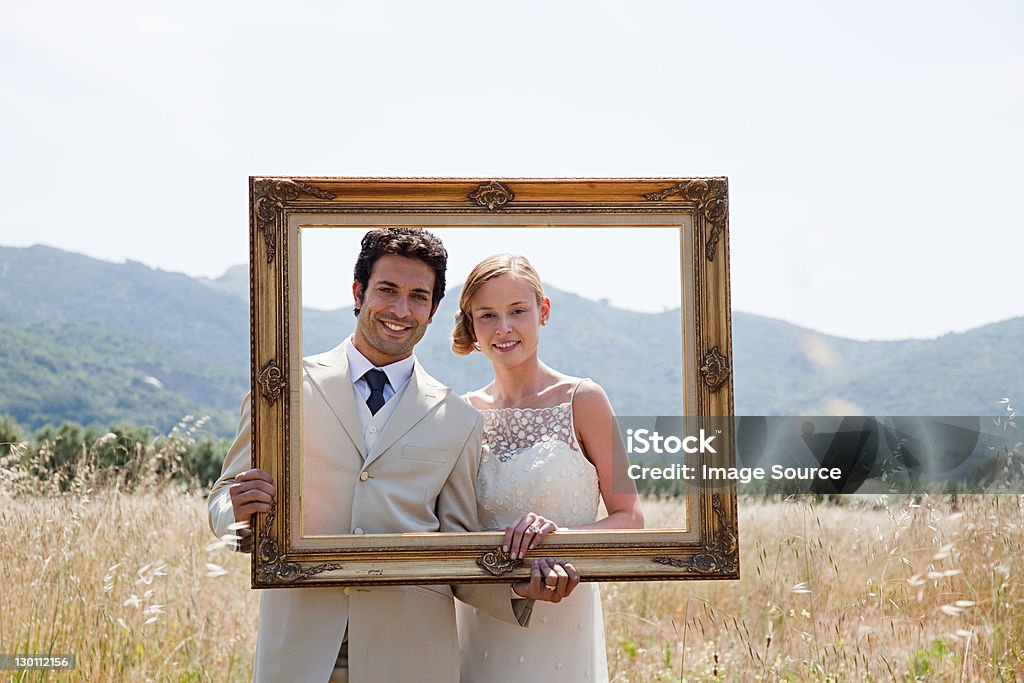 Newlyweds holding vintage picture frame  Wedding Stock Photo