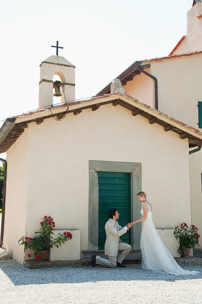 молодоженов за церковь, жениха на одном колене - wedding just married tuscany newlywed стоковые фото и изображения