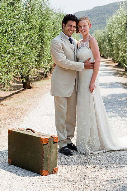 молодоженов на страны дорога с чемодан - wedding just married tuscany newlywed стоковые фото и изображения