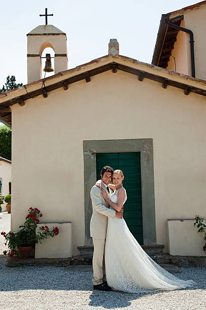 молодоженов за церковь, обнимать - wedding just married tuscany newlywed стоковые фото и изображения