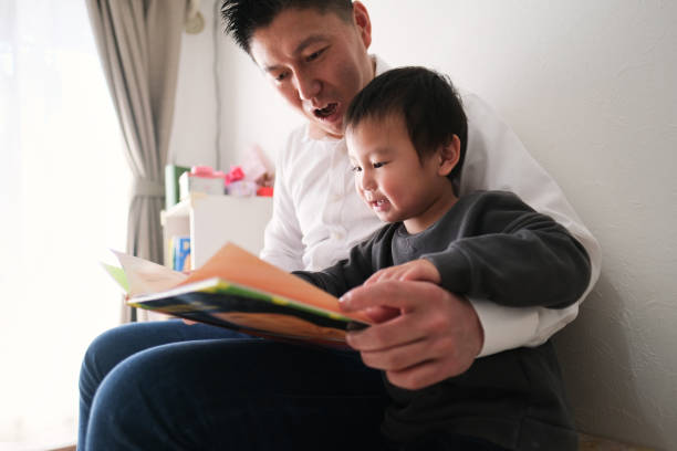 istock Father reading book with son at home 1301124357
