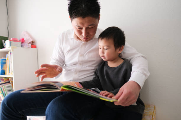 istock Father reading book with son at home 1301124358