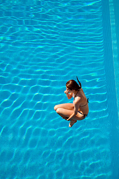 joven mujer salto en piscina - portoferraio fotografías e imágenes de stock