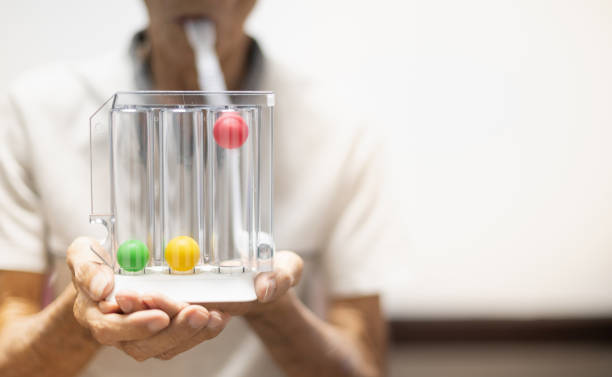 The old patient hand holding the Tri-ball incentive spirometry is medical equipment for post operation. stock photo