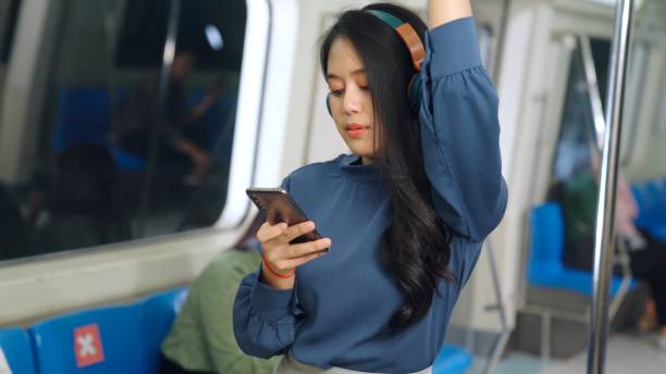 istock Young woman using mobile phone on public train 1301127332