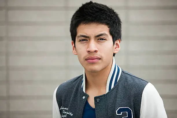 Photo of Young man wearing baseball jacket, portrait