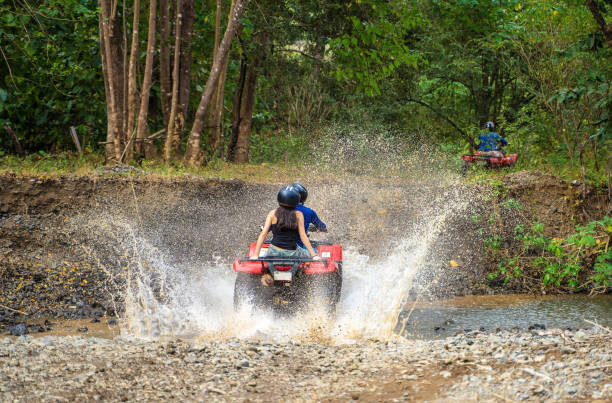 istock Driving quad bikes across small creek Costa Rica 1301131437