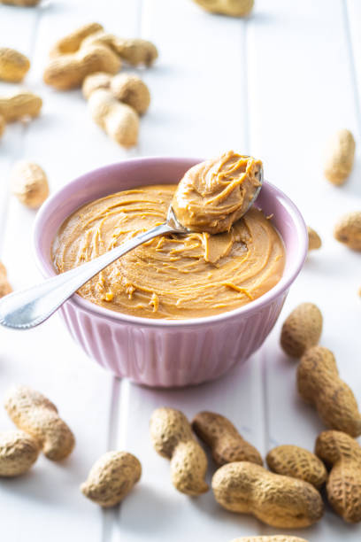 istock Peanut butter in bowl and peanuts 1301132252