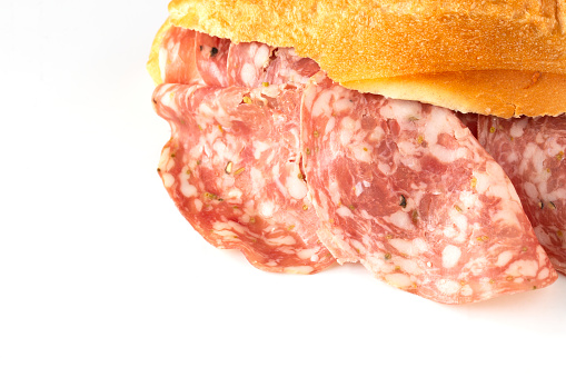 close-up of bun with italian salami ( finocchiona ) on white with copy space