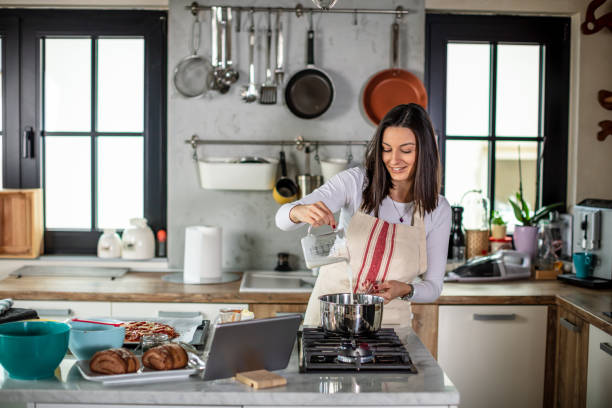 istock Young woman preparing food at kitchen 1301133949