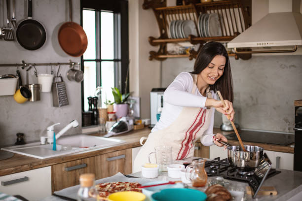 istock Young woman preparing food at kitchen 1301134163