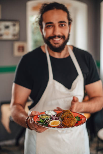 istock Chef Holding a Falafel Plate 1301135116