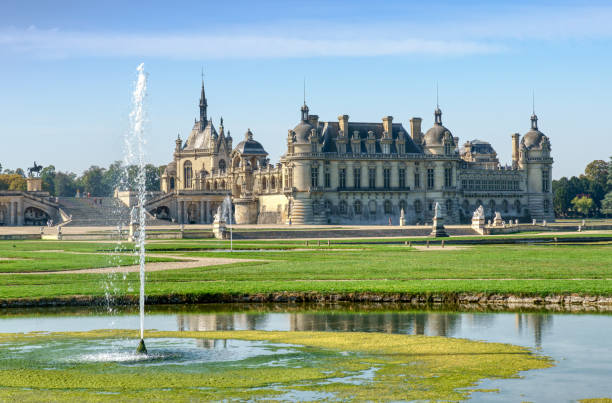 view of chateau de chantilly from le notre garden - france - statue architecture sculpture formal garden imagens e fotografias de stock