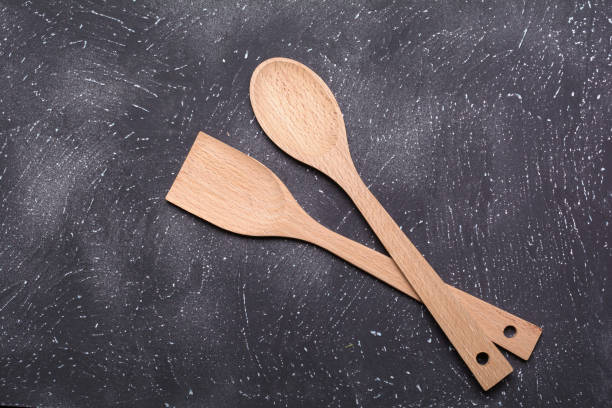 istock Culinary background. Wooden spoon and spatula on a dark textured background.Selective focus. 1301137980