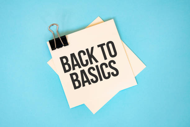 istock Text BACK TO BASICS on sticky notes with copy space and paper clip isolated on red background.Finance and economics concept. 1301138911