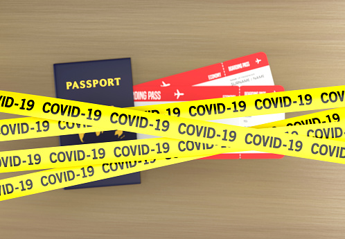 Travel ban due to Covid-19. Passports and tickets on the table with tape barrier.