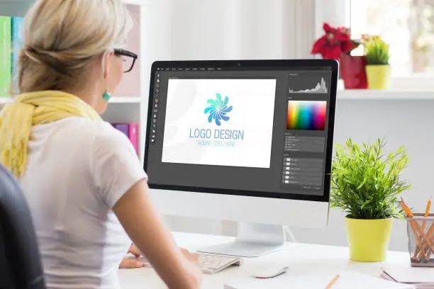 Photo of Graphic designer creating company's logo on desktop computer