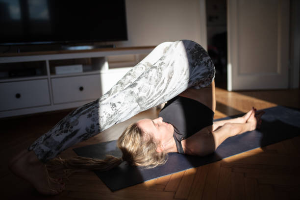 istock Woman practicing yoga at home in plough pose 1301142204