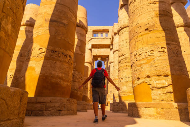 istock A young man walking between the columns with hieroglyphs inside the Karnak Temple, the great sanctuary of Amun. Egypt 1301143819