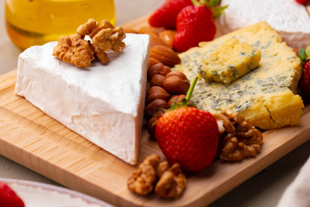 istock Composition of cheese, and fruits on gray table 1301144373