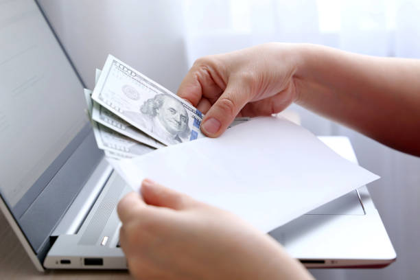 istock Envelope with US dollars in female hands 1301144834