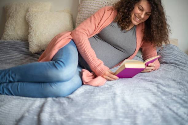 istock Pregnant woman reading a book 1301147998