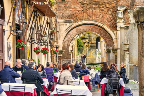 a typical roman cuisine restaurant in the jewish ghetto of rome near the remains of the temple of portico d'ottavia - roman column arch pedestrian walkway imagens e fotografias de stock